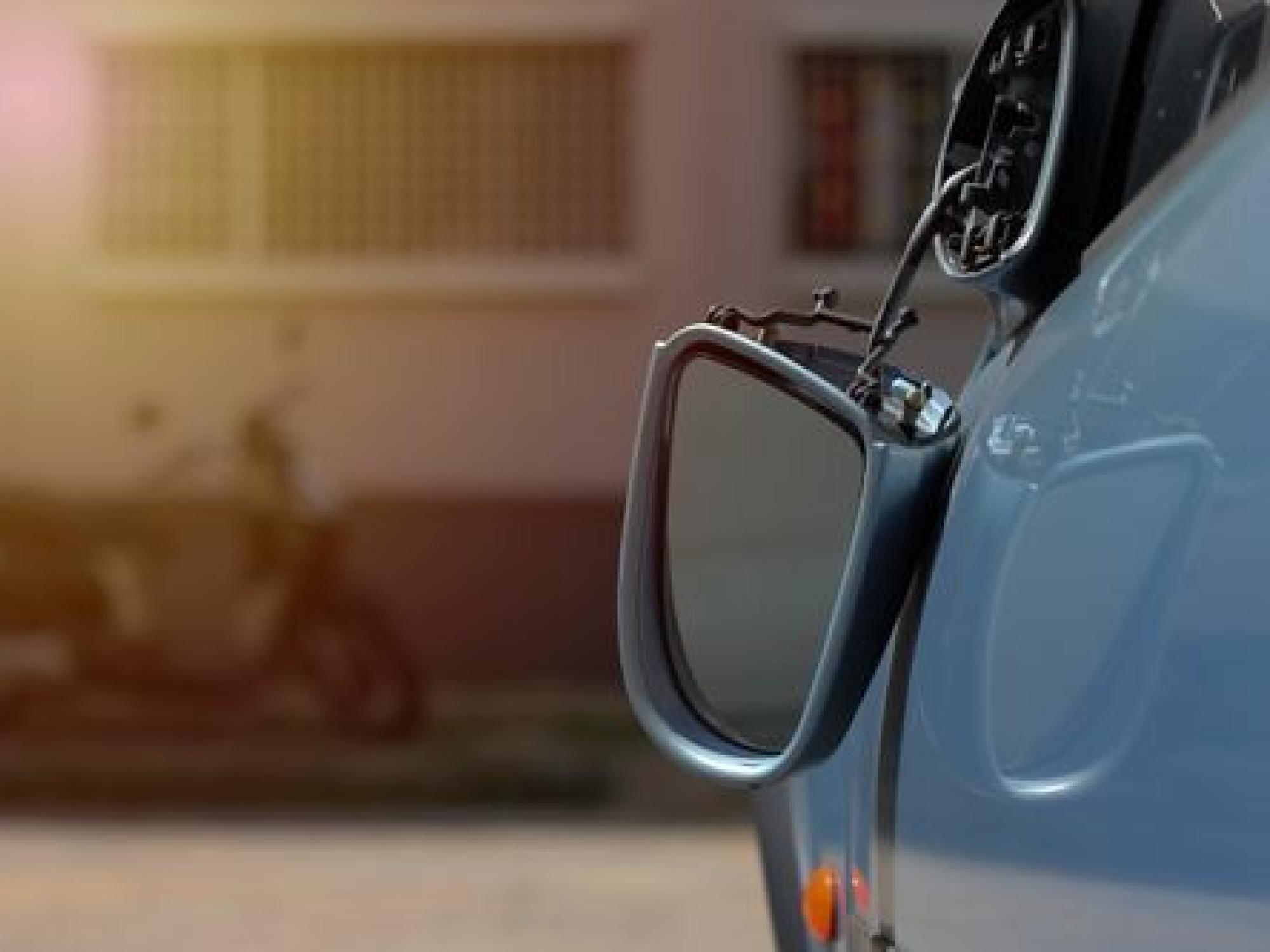 broken mirror on a car hanging off by a cable